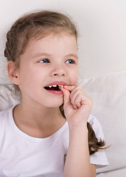 beautiful girl woke up in bed and touches her new tooth - Fotoğraf, Görsel
