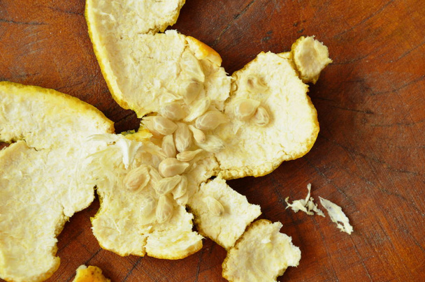  appelsiininkuori ja siemenet jäljellä syömisen jälkeen puinen pöytä
 - Valokuva, kuva