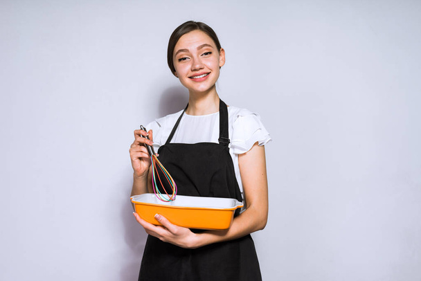 happy young girl cook in a black apron preparing a delicious pie - Foto, Imagen