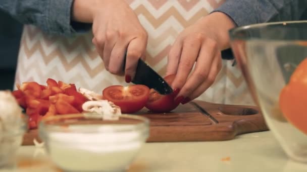 Young woman slices tomatoes - Felvétel, videó