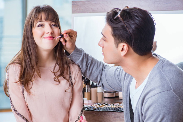 Muž dělá make-up pro roztomilé ženy v salonu krásy - Fotografie, Obrázek