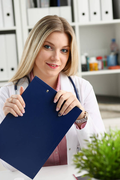 Beautiful smiling female doctor hold clipboard - Фото, изображение