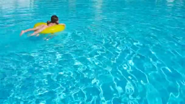 Niñas tienen un montón de diversión con círculo de goma inflable en la piscina
 - Metraje, vídeo