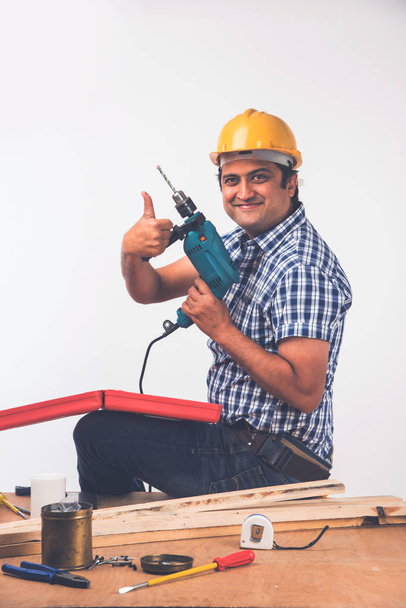 Handsome Indian Carpenter or wood worker in action, isolated over white background - Photo, Image