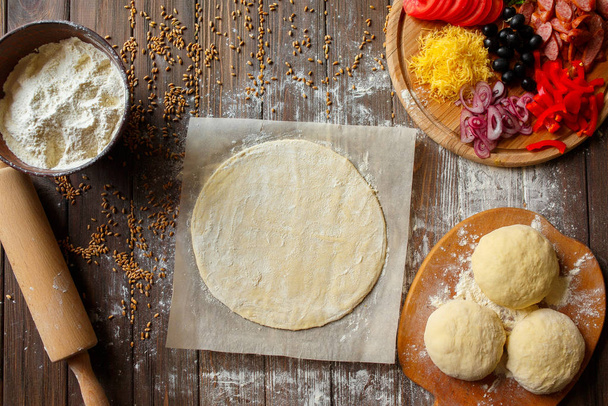 Pizza dough with ingredients on wood - Foto, Bild