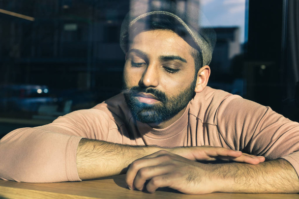 Portrait of an Indian man posing behind a glass - Photo, image