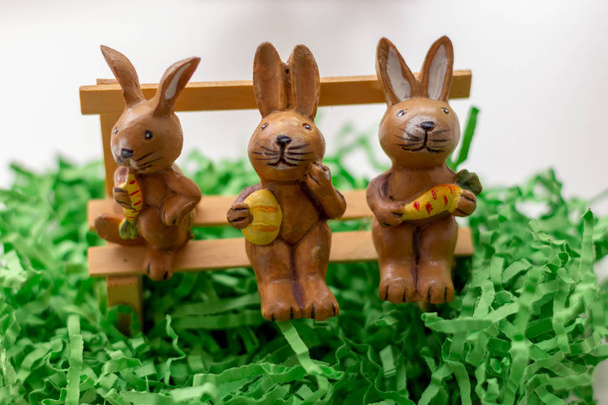 decoração coelhos sentados em um banco perto de uma janela
 - Foto, Imagem