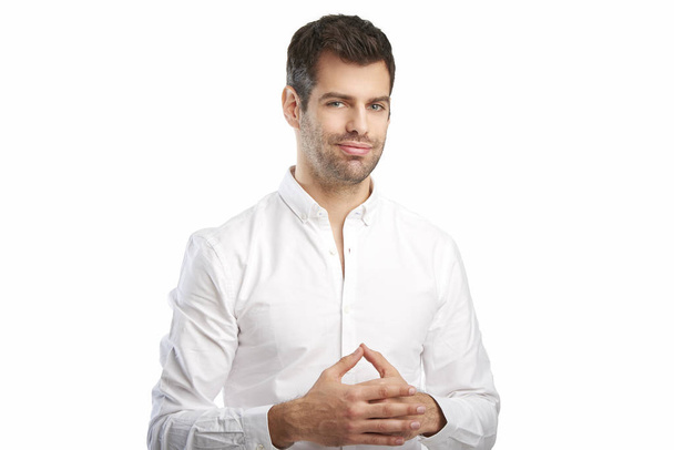 Portrait of thinking young businessman wearing shirt while standing against at isolated white background with copy space.  - Фото, зображення