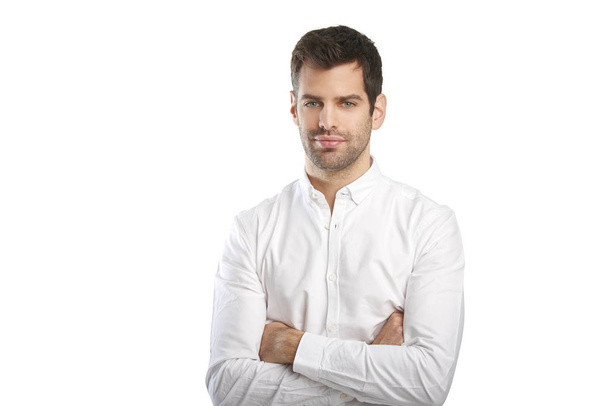 Portrait of young businessman wearing shirt while standing with folded arms against at isolated white background with copy space.  - Fotoğraf, Görsel