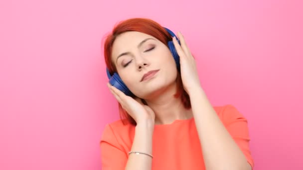 Рыжая женщина наслаждается музыкой в наушниках
 - Кадры, видео