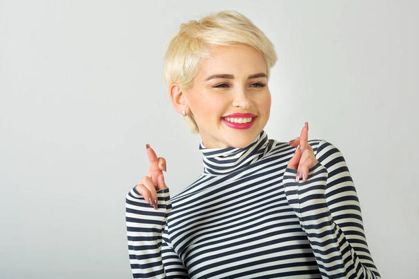 happy beautiful young girl with a smile on her face with a short hairstyle on a light background - Foto, Imagem