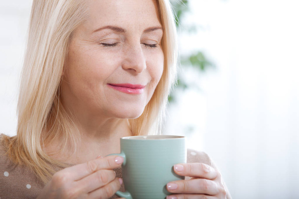Portrait of happy blonde with mug in hands - Фото, изображение