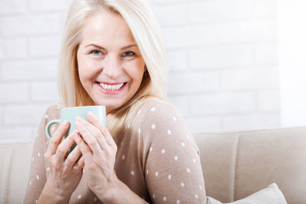 Portrait of happy blonde with mug in hands - Фото, зображення