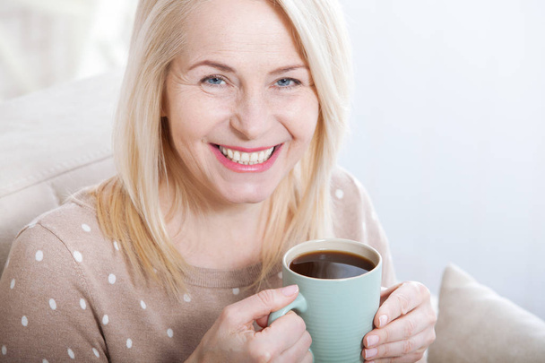 Portrait of happy blonde with mug in hands - Foto, Imagen