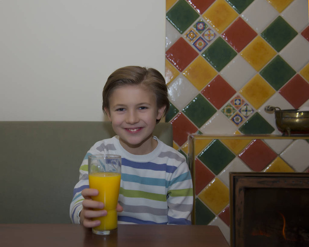 Jongen met glas sinaasappelsap  - Foto, afbeelding