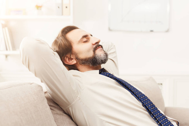 Розслаблений бізнесмен в сучасному білому офісі
 - Фото, зображення
