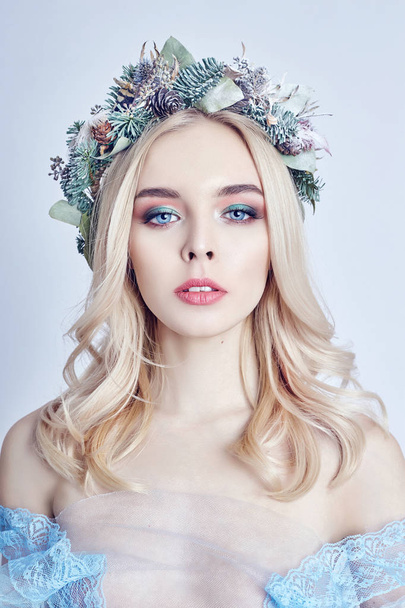 Portrait of a blonde woman with a wreath on her head and a blue  - Photo, image
