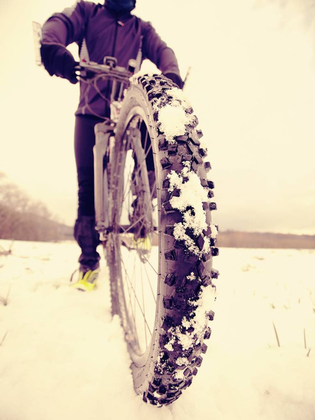 Велогонщик на зимнем велосипеде остается в снегу. Зимняя спортивная концепция
. - Фото, изображение