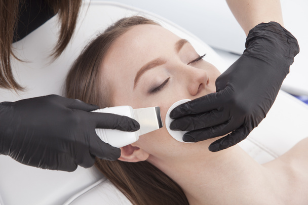 Beautiful woman is having a facial treatment in spa. Cavitation peeling. - Photo, Image