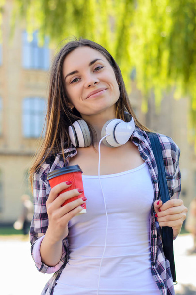 Happy cheerful smiling young student listening to music and drin - Foto, Imagem