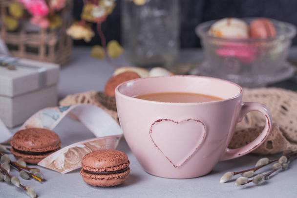 Pink coffee mug with sweet pastel french macaroons, gift box and - Fotoğraf, Görsel