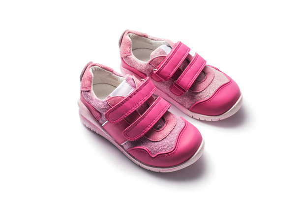 Дитяча дівчинка маленьке рожеве спортивне взуття ізольоване на білому
 - Фото, зображення