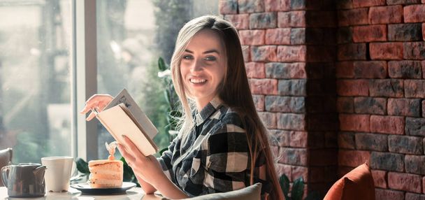 Красивая девушка читает книгу в кафе
 - Фото, изображение