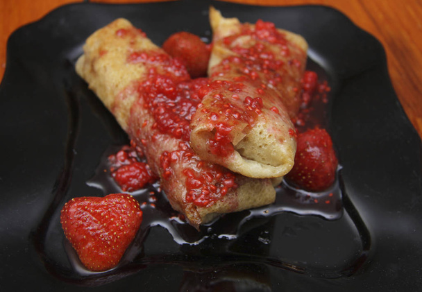 Tortitas enrolladas rellenas de requesón y mermelada de fresa
 - Foto, Imagen