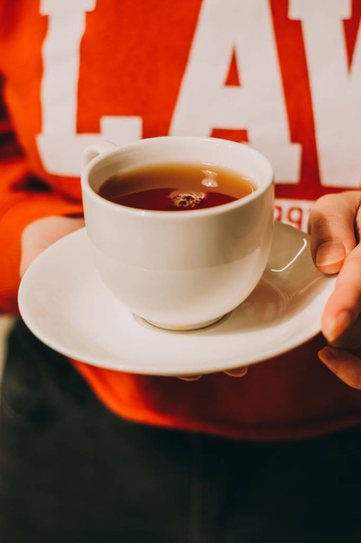 Gros plan de la main d'une femme tenant une tasse de thé chaud
 - Photo, image