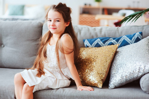 cute happy 5 years old child girl relaxing alone at home on cozy couch - Fotoğraf, Görsel