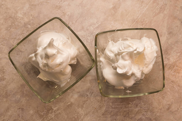 Os merengues de creme em um recipiente de vidro
 - Foto, Imagem