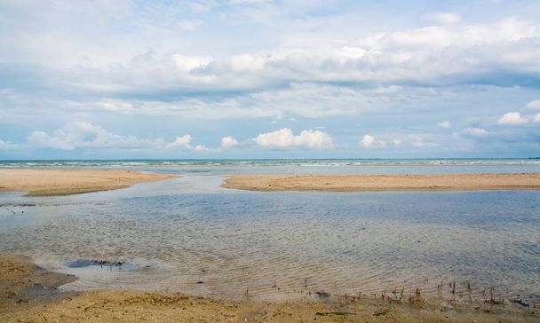 Морской берег затопил косу, волны, ландшафт и голубое небо с белыми облаками
 - Фото, изображение