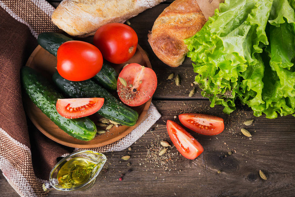 tomato, cucumber, lettuce, baguette, olive oil and spices - Foto, afbeelding