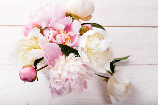 繊細な花弁の花と木の板に白リボン白ピンクの牡丹。オーバーヘッド平面図、フラットが横たわっていた。領域をコピーします。誕生日、母のバレンタイン、女性、結婚式の日の概念 - 写真・画像