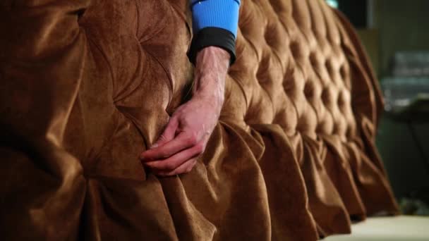 L'homme redresse le tissu sur un canapé dans un atelier d'assemblage de meubles
 - Séquence, vidéo