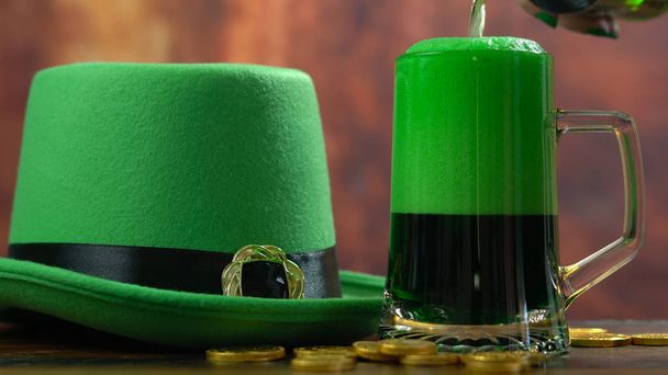 St Patricks päivä kaatamalla vihreää olutta vihreä menninkäinen hattu
 - Valokuva, kuva