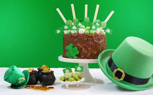 День Святого Патрика Стол для вечеринок с шоколадным тортом, шляпа лепрекона и блики объектива
. - Фото, изображение
