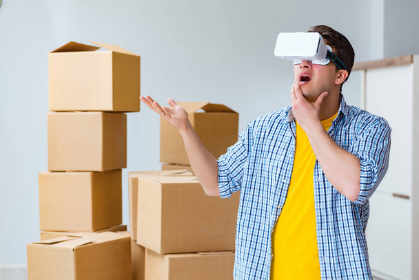 Young man wearing VR glasses moving in new apartment - Photo, Image