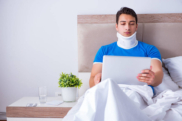 Jongeman met nekletsel in bed - Foto, afbeelding