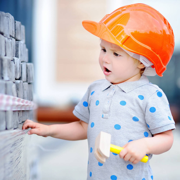 Little builder in hardhats with hammer working outdoors - 写真・画像