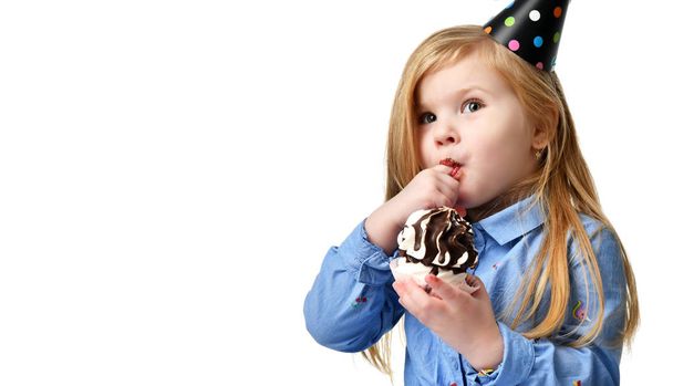 Three years girl kid eat sweet chocolate cake celebrating in birthday cap isolated  - Foto, Imagem