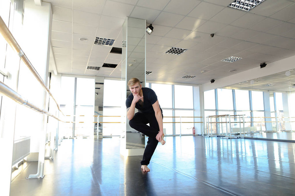 Taniec trener siedzi na sznurek z odchylane do przodu. - Zdjęcie, obraz