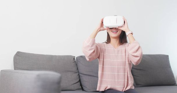 Nainen katsella VR laitteen kotona
  - Valokuva, kuva