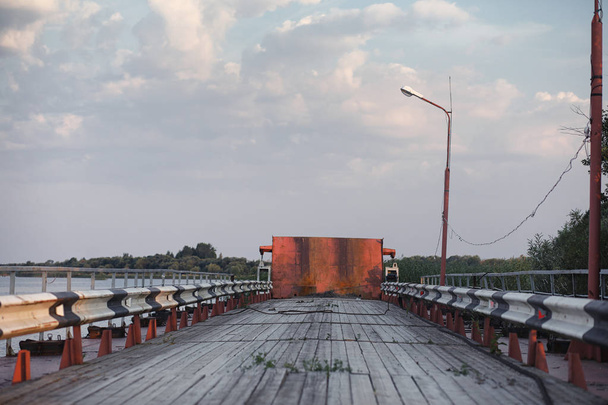 Holzbrücke am Ufer des Flusses. eine Holzstraße mit Säulen. Pfanne - Foto, Bild