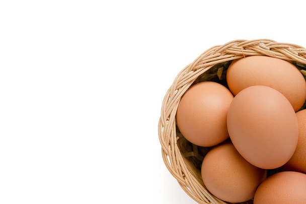 Jaja w wiklinowym koszu na białym tle - Zdjęcie, obraz