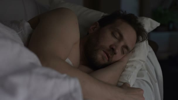 Adult bearded man sleeping in bed, exhausting day, sound sleep and night rest - Felvétel, videó