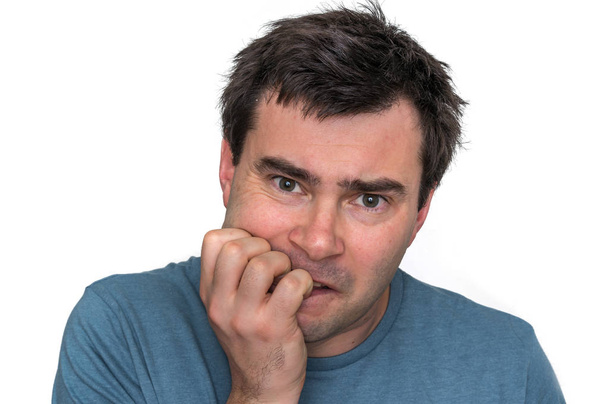 Nerveuze man zijn geïsoleerd op witte nagels te bijten - Foto, afbeelding