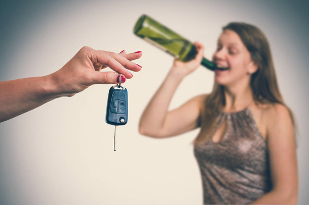 Femme buvant de l'alcool et son ami montrant des clés de voiture
 - Photo, image