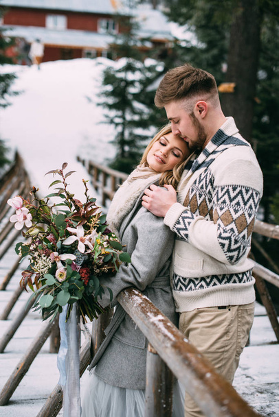 Uomo abbracciare donna sul ponte di legno in montagna
 - Foto, immagini
