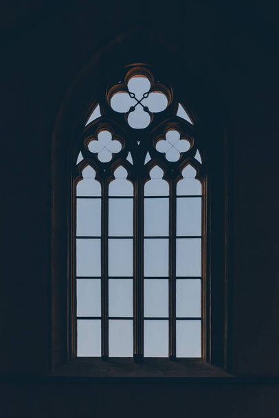 Odwrócony sylwetka dużego średniowiecznego okna w podświetlenie w stylu gotyckim. - Zdjęcie, obraz